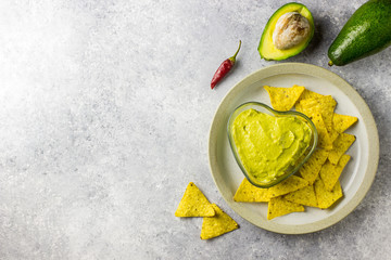 Fresh guacamole sauce in glass bowl and mexican corn chips