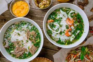 Assorted asian dinner, vietnamese food. Pho ga, pho bo, noodles, spring rolls