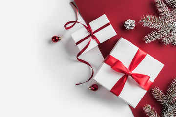 Christmas gift boxes with red ribbon, decoration, Fir branches, pine cones on white and red paper...