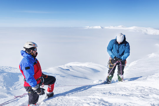 Two Professional Climbers making trekking on snowy slope.