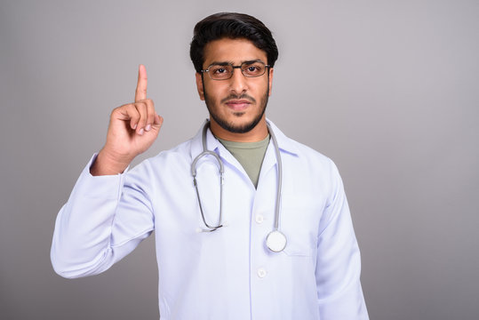 Portrait Of Indian Man Doctor Pointing Finger Up