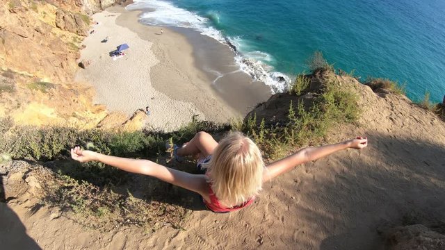Carefree female from promontory looks Pirates Cove, a hidden sandy beach in a small cove on west side of Point Dume on Malibu coast in CA, United States. Caucasian woman in California West Coast.
