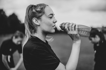 Female football player drinking from a water bottle