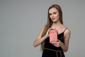 Young blond girl in black  dress with red present package