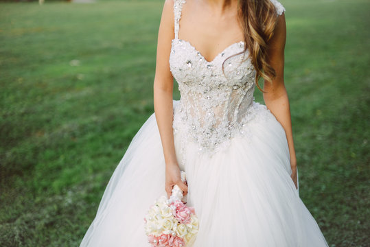 Bride holds her wedding dress