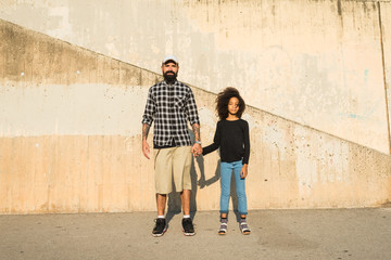 Dad and daughter holding hands.