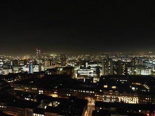 Aerial night time photo taken above the Leeds City Center at Christmas Time showing the Leeds Town Hall and buildings and roads around West Yorkshire.