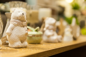 Cute white Christmas teddy bear made of porcelain is on the shelf in the background  other xmas toys