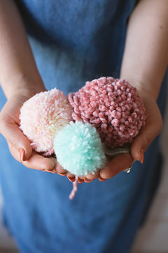 Close up of hands holding home made pom poms
