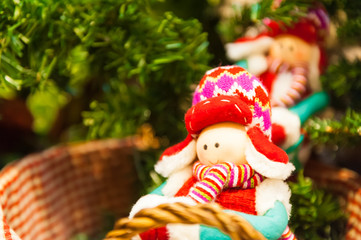 Old wooden toy with a red bow ribbon on Christmas Fir Tree Toys Burning Candles, Boxes, Balls, Pine Cones, Walnuts, Branchesin the background other decorations and garlands. copy space.
