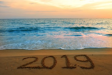 Happy new year concept, 2019 put on sand beach in sunrise.