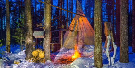 Nomadic peoples. Tipi. Dwelling nomadic Indians. Dwellings of the Tipi Indians. Dwelling in the winter forest. Bonfire on the snow. Snow. Yurt.