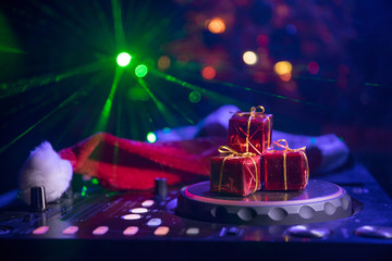 Dj mixer with headphones on dark nightclub background with Christmas tree New Year Eve. Close up...