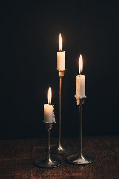 Burning Candles in Brass Candlesticks