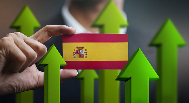 Nation Growth Concept, Green Up Arrows - Businessman Holding Card of Spain Flag