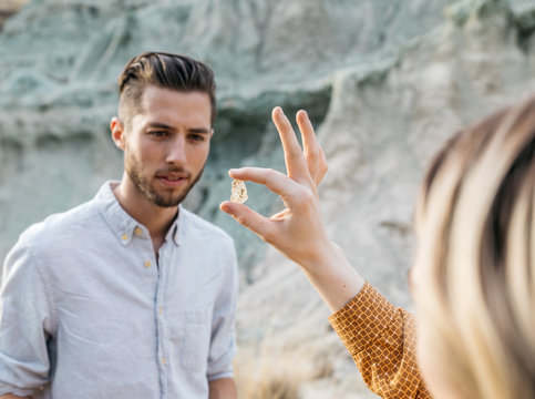 Young adult female shows male friend a crystal rock 