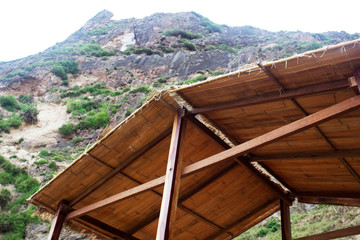 Low angle view of bungalow straw roof mountain sky