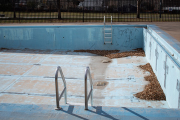 empty urban pool with grafitti and leaves