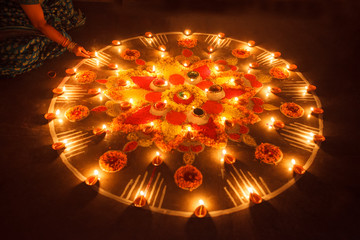 A woman is lightening a diya in the festival of Diwali