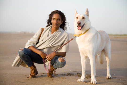 Young Woman On The Beach With Big White Dog