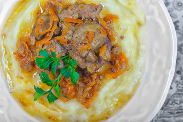 Fried chicken liver with carrots and onion and garnish of mashed potatoes,served with parsley and marinated garlic arrows. Top view