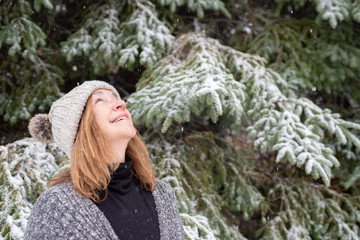 woman looking up at snow falling