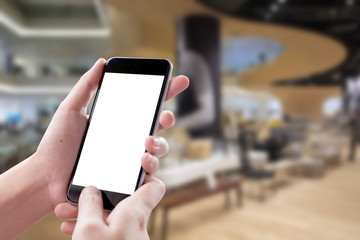 Smartphone blank screen in woman hands over blurred background at Holel.