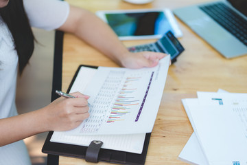 Business and finance concept of office working, Businesswoman discussing analysis chart and using calculator with business document on desk in office. Selective focus,Vintage effect.