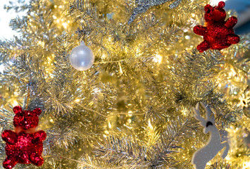 Obraz na płótnie Canvas Close up Christmas tree decoration with white balls, silver reindeer and red bear and golden light. Xmas background. Christmas and Happy New Year background. Background for Christmas theme.