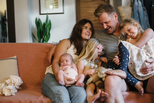 Cuddling family of five squished together on living room couch