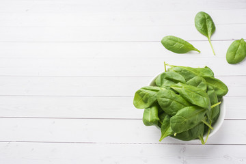 Fresh spinach leaves in a plate on a light table.