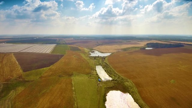 Backward flight over the country fields and lakes. FullHD 1080p.
