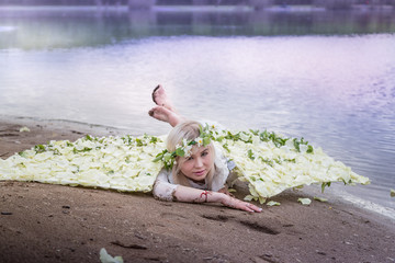 Nice blonde girl with white flower wings near river