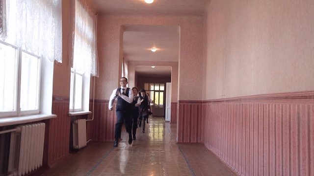 A group of children running along the corridor in the school