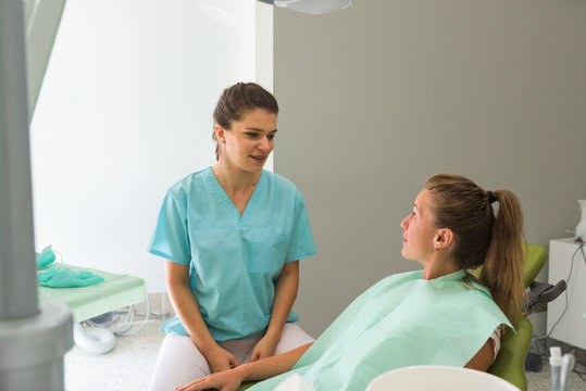 Female dentist talking with her patient 
