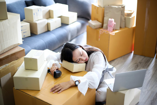 Tired unhappy of   Young asian girl is freelancer Start up small business owner writing address on cardboard box at workplace,Shipping shopping online small business entrepreneur SME or freelance
