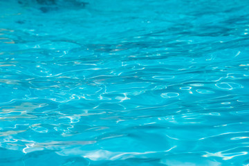Fototapeta premium Blue and bright water surface and ripple wave with sun reflection in swimming pool