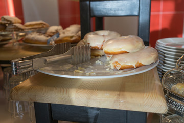 Dish with delicious donuts in the window of the cafe.