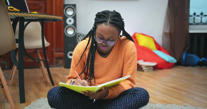 Portrait of concentrated african female student doing homework