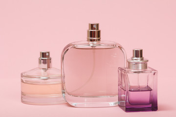 Bottles with women perfume on a pink background.