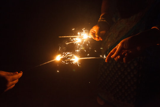 Woman's hand holding sparkler and celebrating festival
