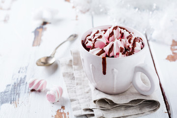 Chocolat chaud avec des bonbons à la guimauve dans une tasse en céramique rustique blanche sur un vieux fond en bois vintage clair. Mise au point sélective.