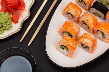 Uramaki California. Sushi rolls and plate with red pickled ginger and wasabi.