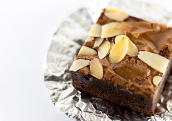 Close up chocolate brownie on foil and white background