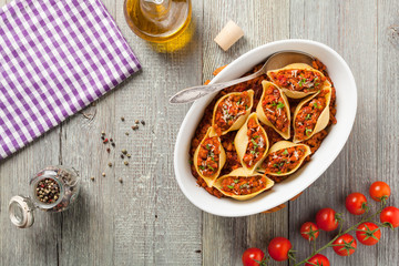 Italian pasta Conchiglioni Rigati stuffed with dry tomatoes and meat.