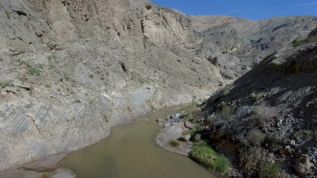 Aerial drone pull back of lonely river in giant rocky canyon