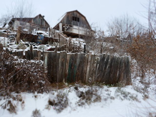 mess an abandoned house and a fence in winter.