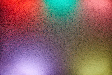 Rays of different colors light up the wall