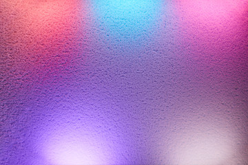 Rays of different colors light up the wall