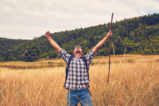 Man hiker with arms wide open in the field.
